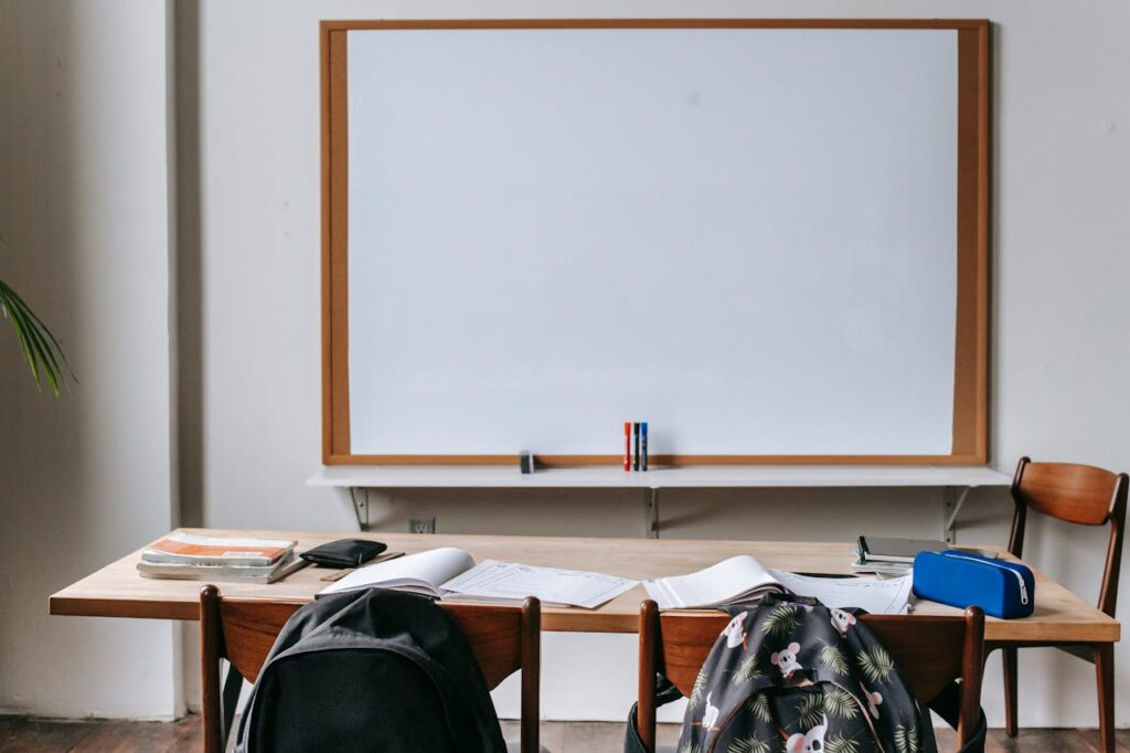 Classroom with whiteboard and desk with stationery